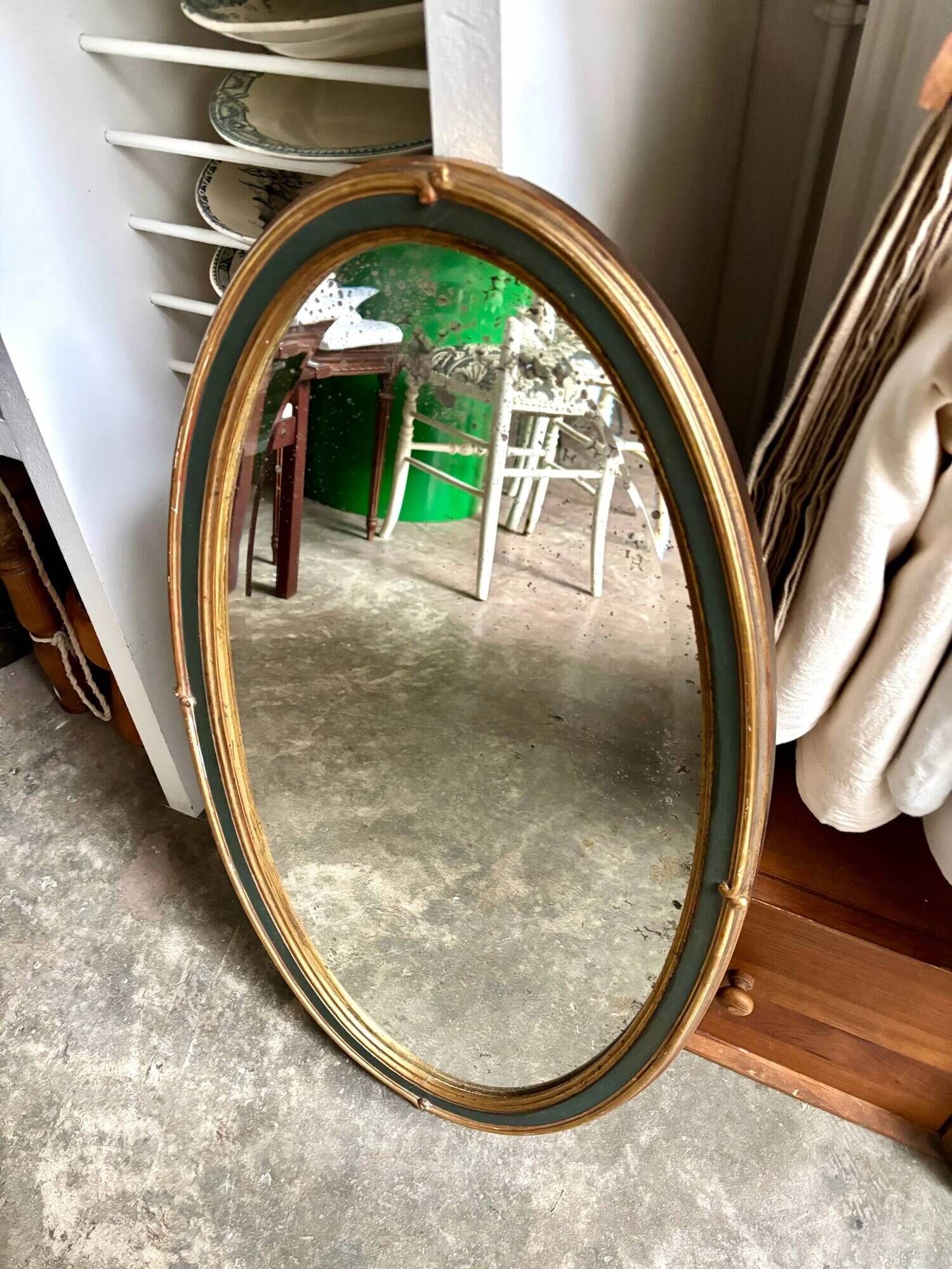 Oval mirror in wood and green and gold stucco, 75 x 42 cm
