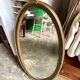 Oval mirror in wood and green and gold stucco, 75 x 42 cm