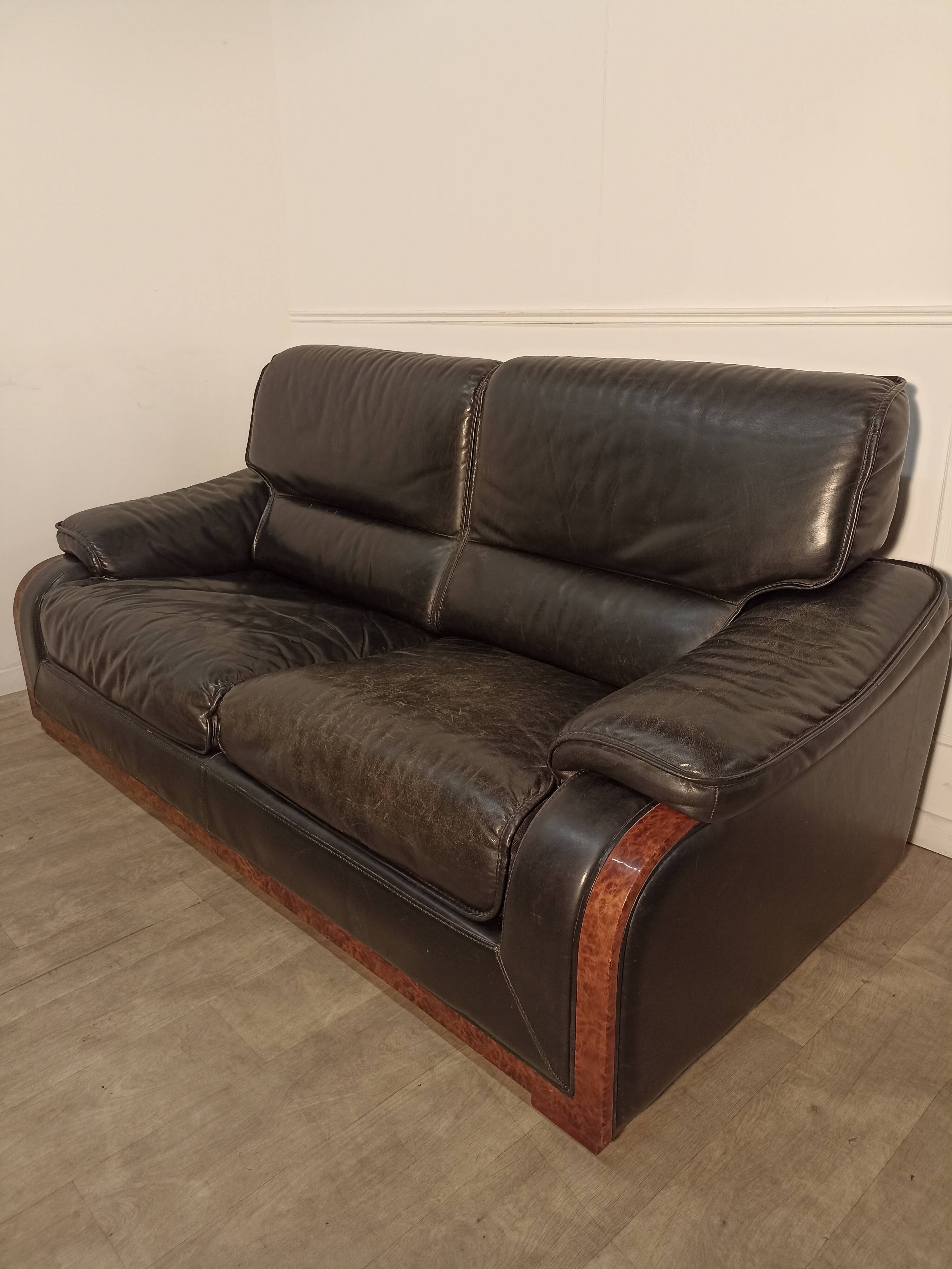 Black leather sofa and wooden armrests