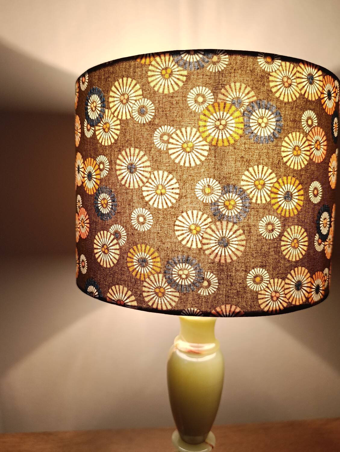 Table lamp with light green onyx base, fabric shade with a khaki background.