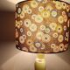 Table lamp with light green onyx base, fabric shade with a khaki background.