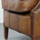 Fauteuil à oreilles de style anglais couleur cognac en cuir de vache.