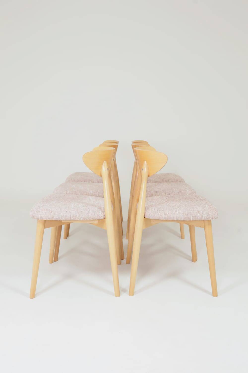 Set of 6 pale pink dining chairs in natural wood.