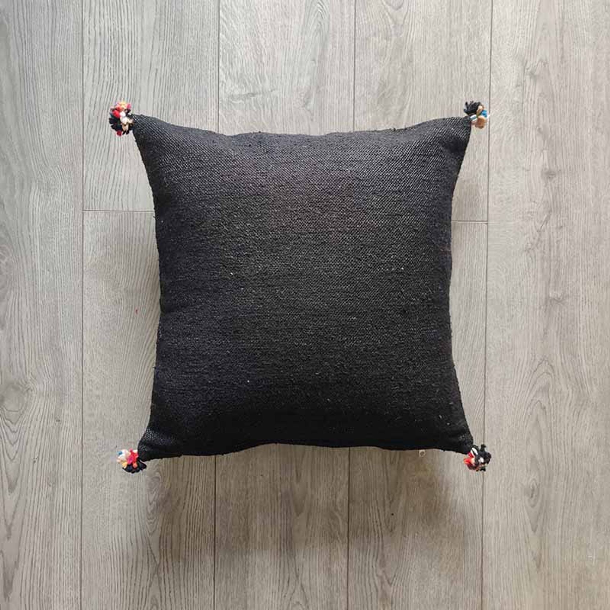 Coussin marocain noir à pompon en coton