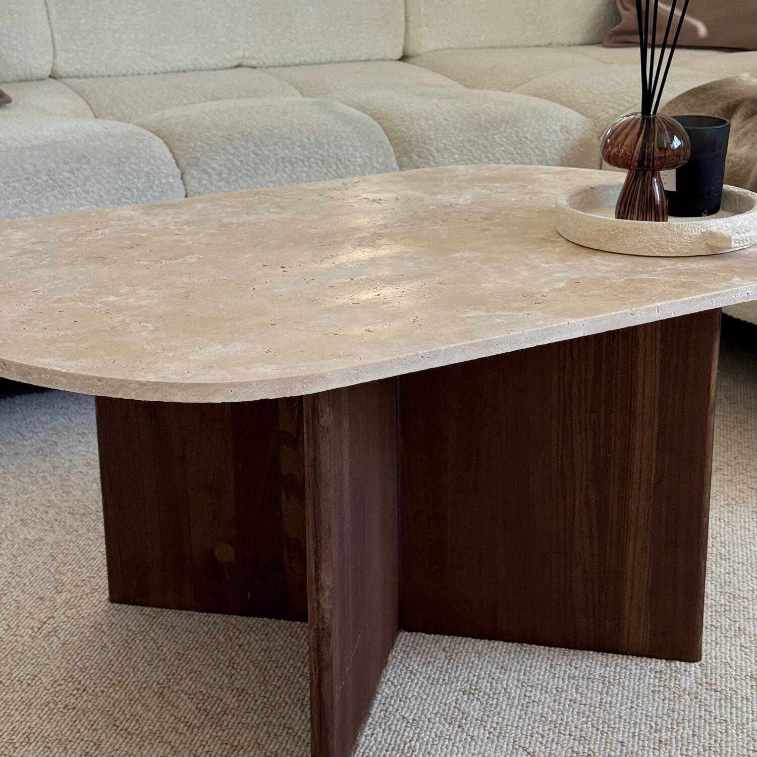 Oval coffee table in travertine and dark oak.