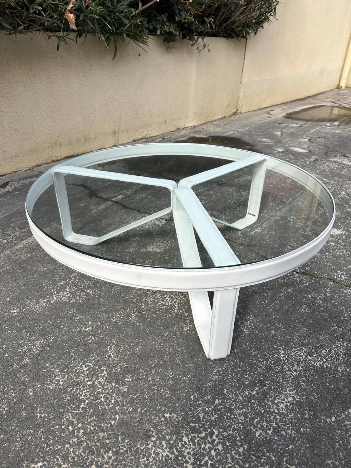Round coffee table with a metal/leather frame and glass top by Roche Bobois.