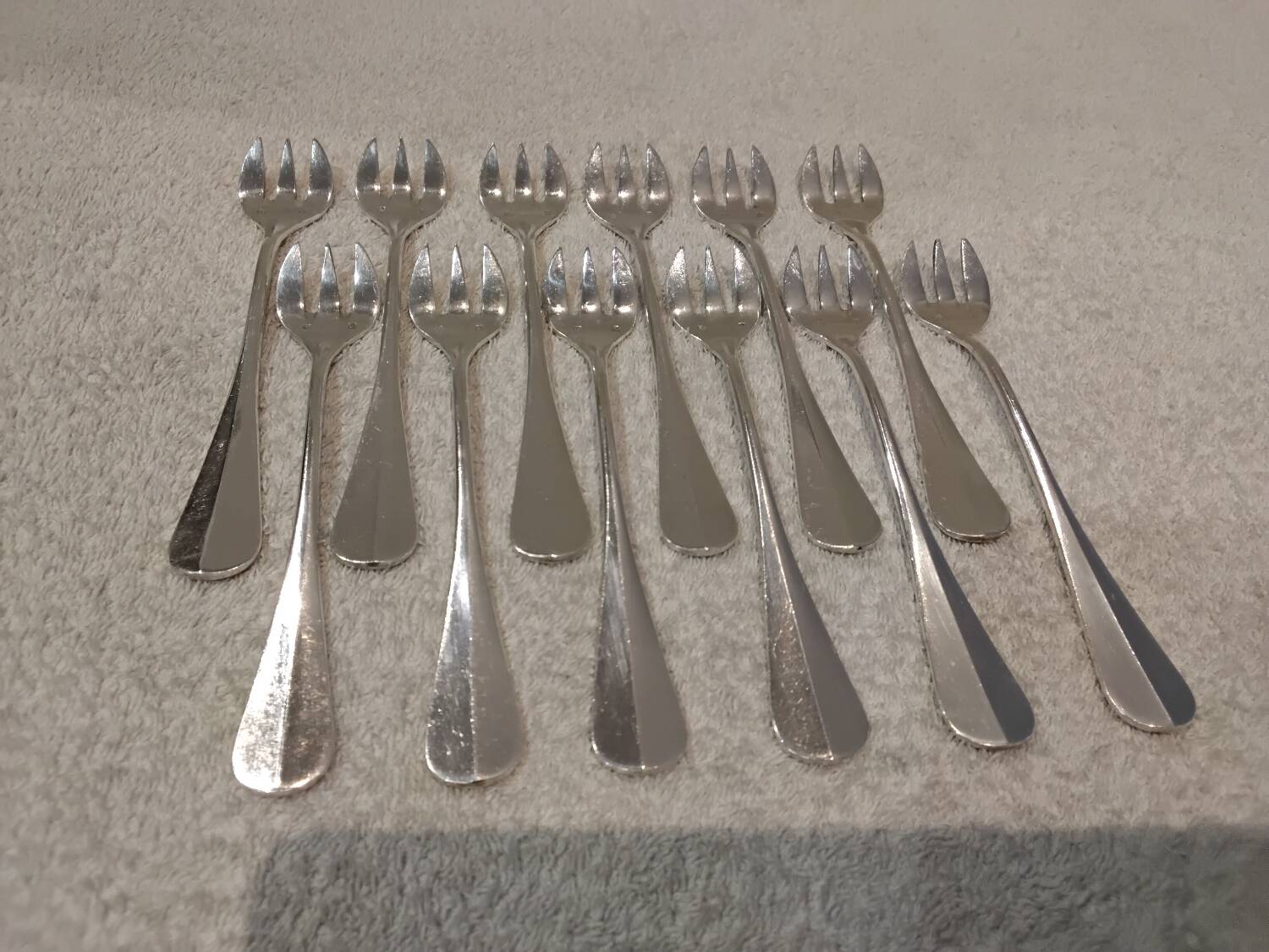 12 silver-plated oyster forks by silversmith J Brille with stick handles.