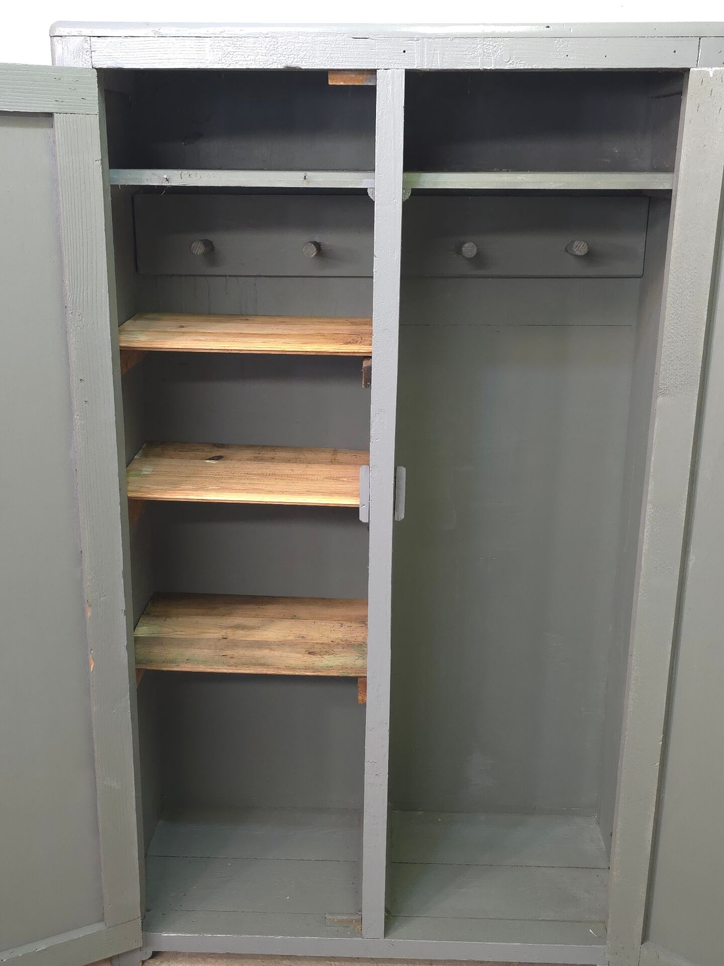 Curved wardrobe workshop locker made of wood repainted in grey.