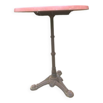 Round bistro table with cast iron base and pink marble style top