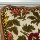 Convertible armchair with brocade fabric and floral patterns.