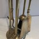 Neoclassical brass fire accessory with duck head decorations.