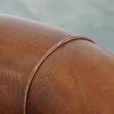 Sheep leather club chair in a cognac color and finished with piping