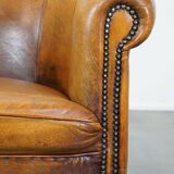 Subtle sheepskin club chair finished with decorative studs