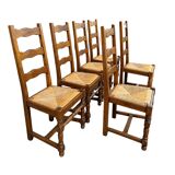 Set of 6 solid wood chairs with straw seats.