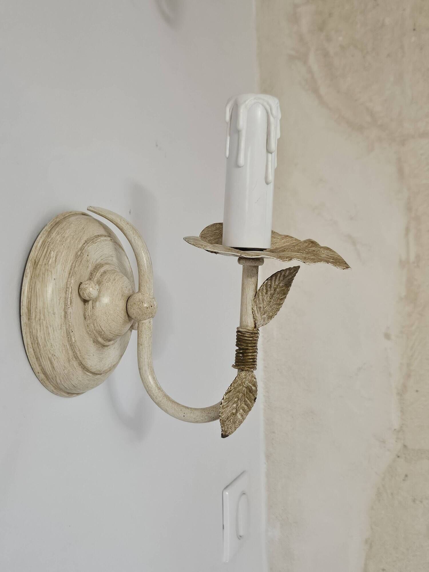 Pair of cream patinated metal wall sconces with floral decoration.