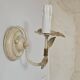 Pair of cream patinated metal wall sconces with floral decoration.