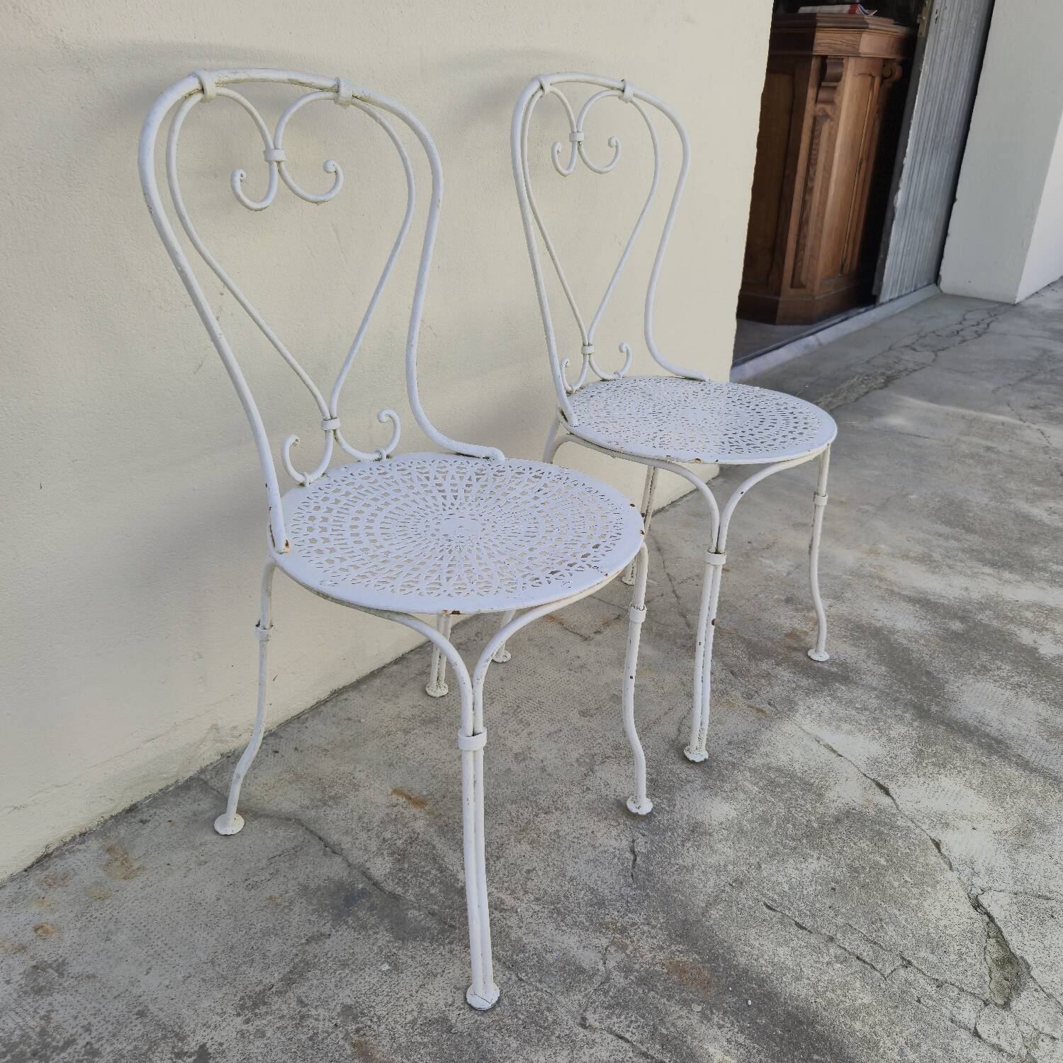Pair of wrought iron garden chairs, antique manufacture