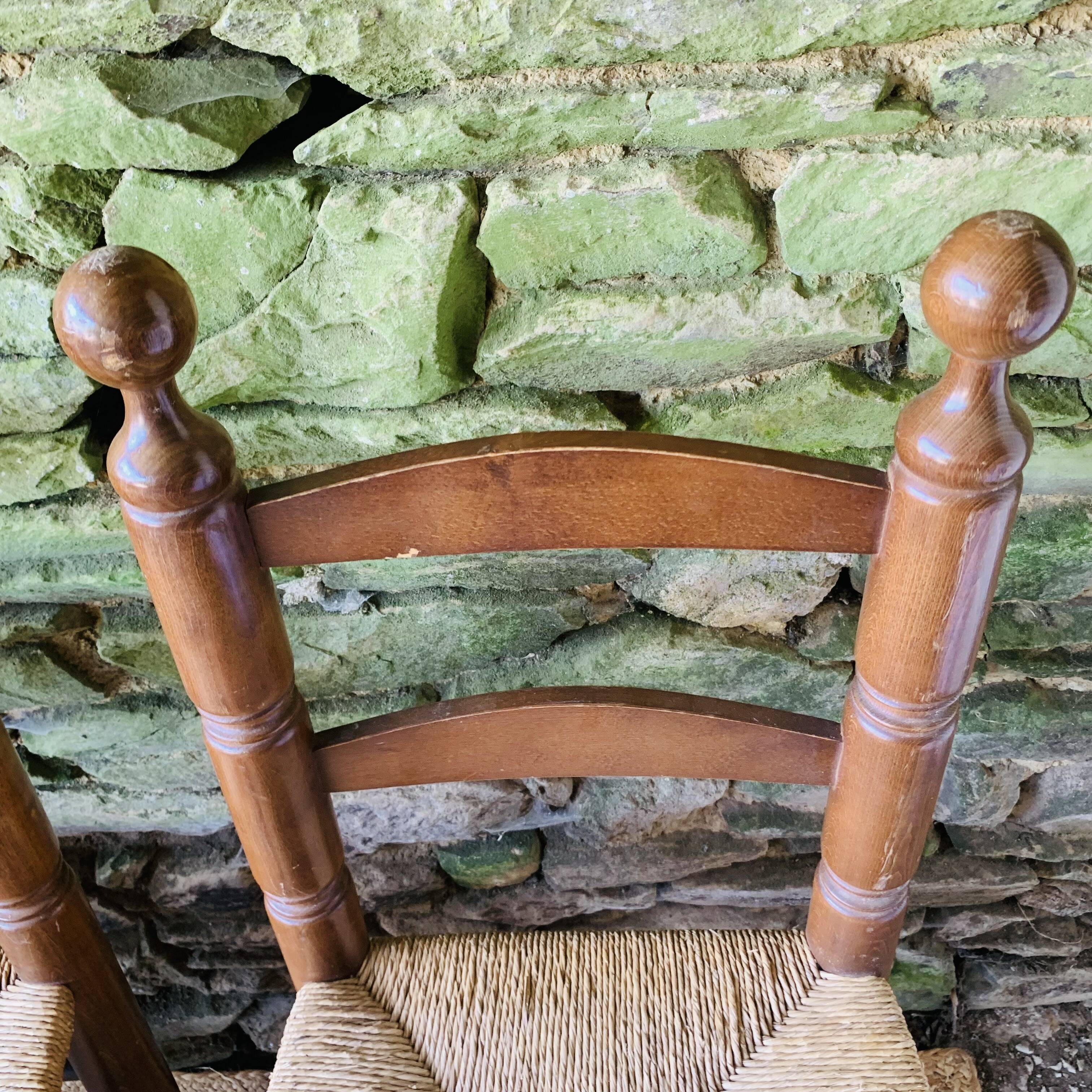 Set of 4 solid wood chairs with straw seats.