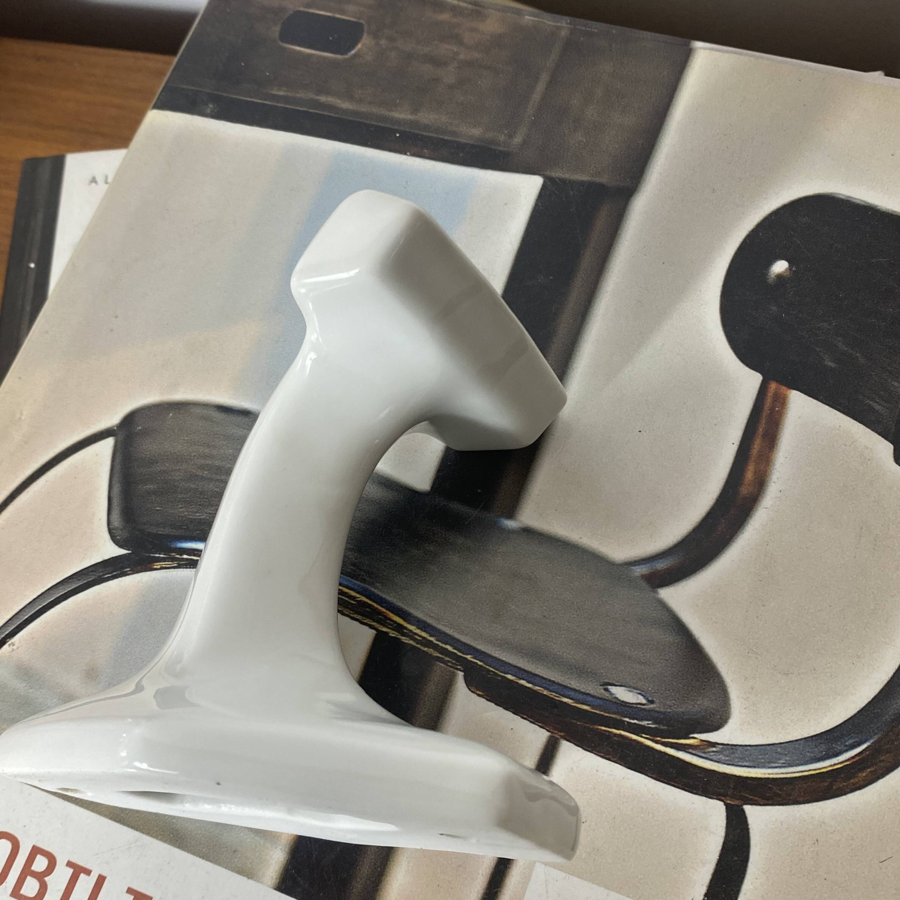 An antique white porcelain coat hook towel holder.