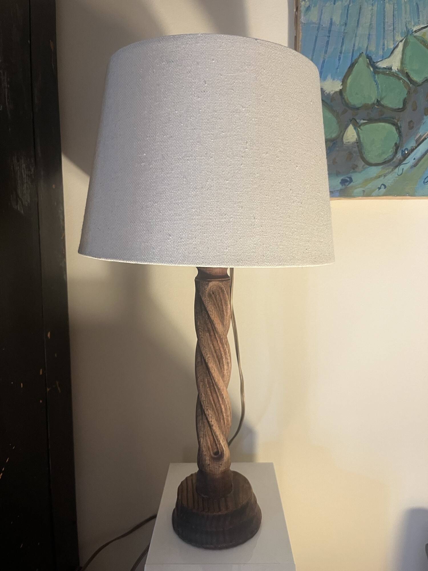 Wooden floor lamp with white tweed shade.