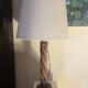 Wooden floor lamp with white tweed shade.