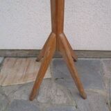 Antique light wood coat rack with splayed legs.