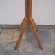 Antique light wood coat rack with splayed legs.