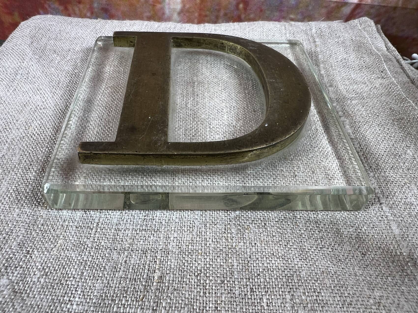 Metal letter D on glass plate
