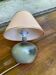 Vintage green ceramic bedside lamp with a pink-beige lampshade.
