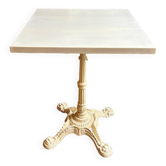 Bistro table in beige cast iron and off-white wood.
