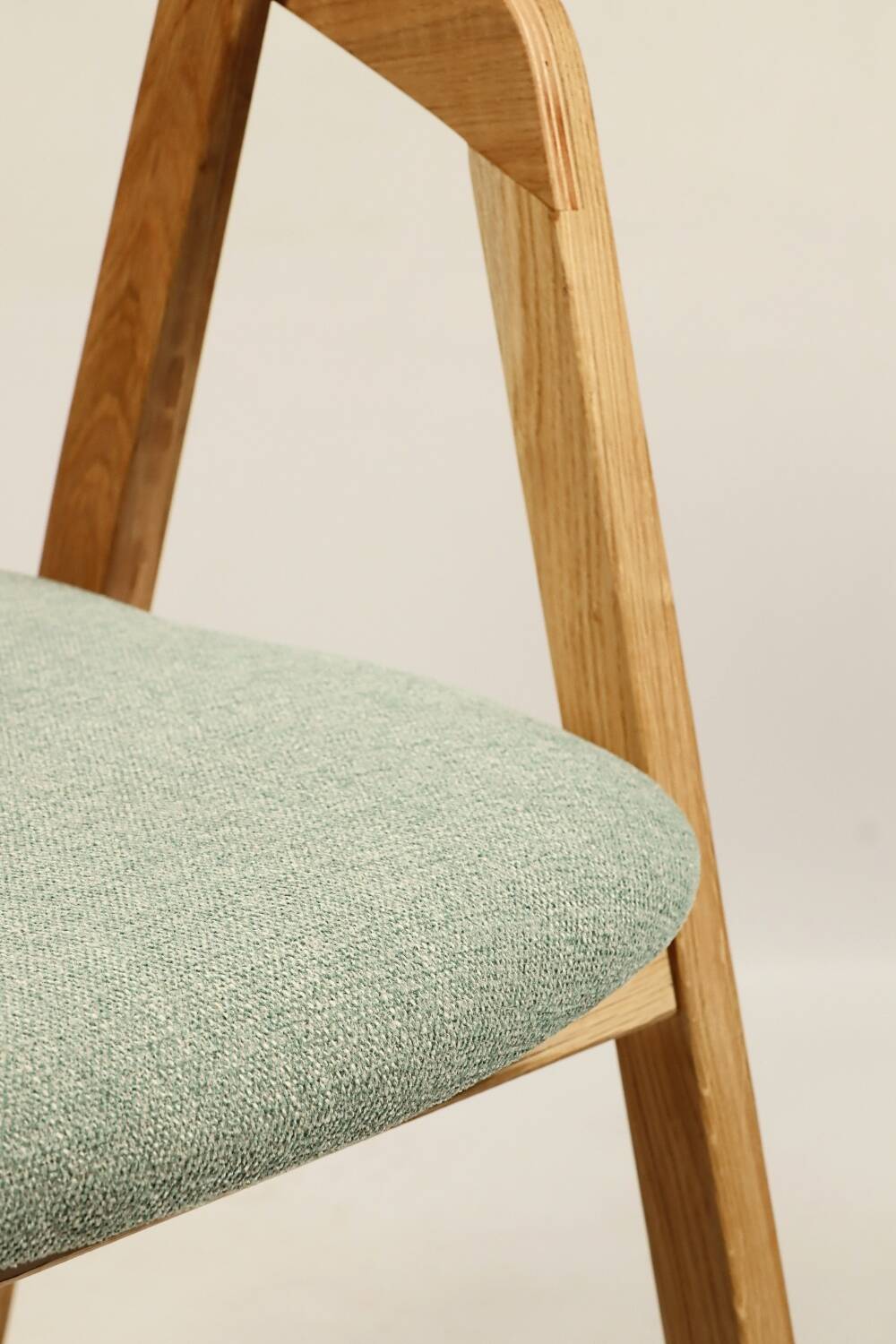 Vintage dining chair in light oak with natural linen pastel green fabric.