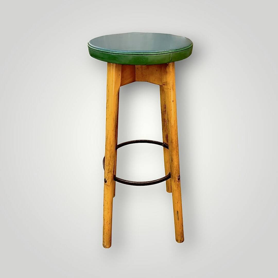 Old solid wood bar stool, metal footrest, green leatherette seat