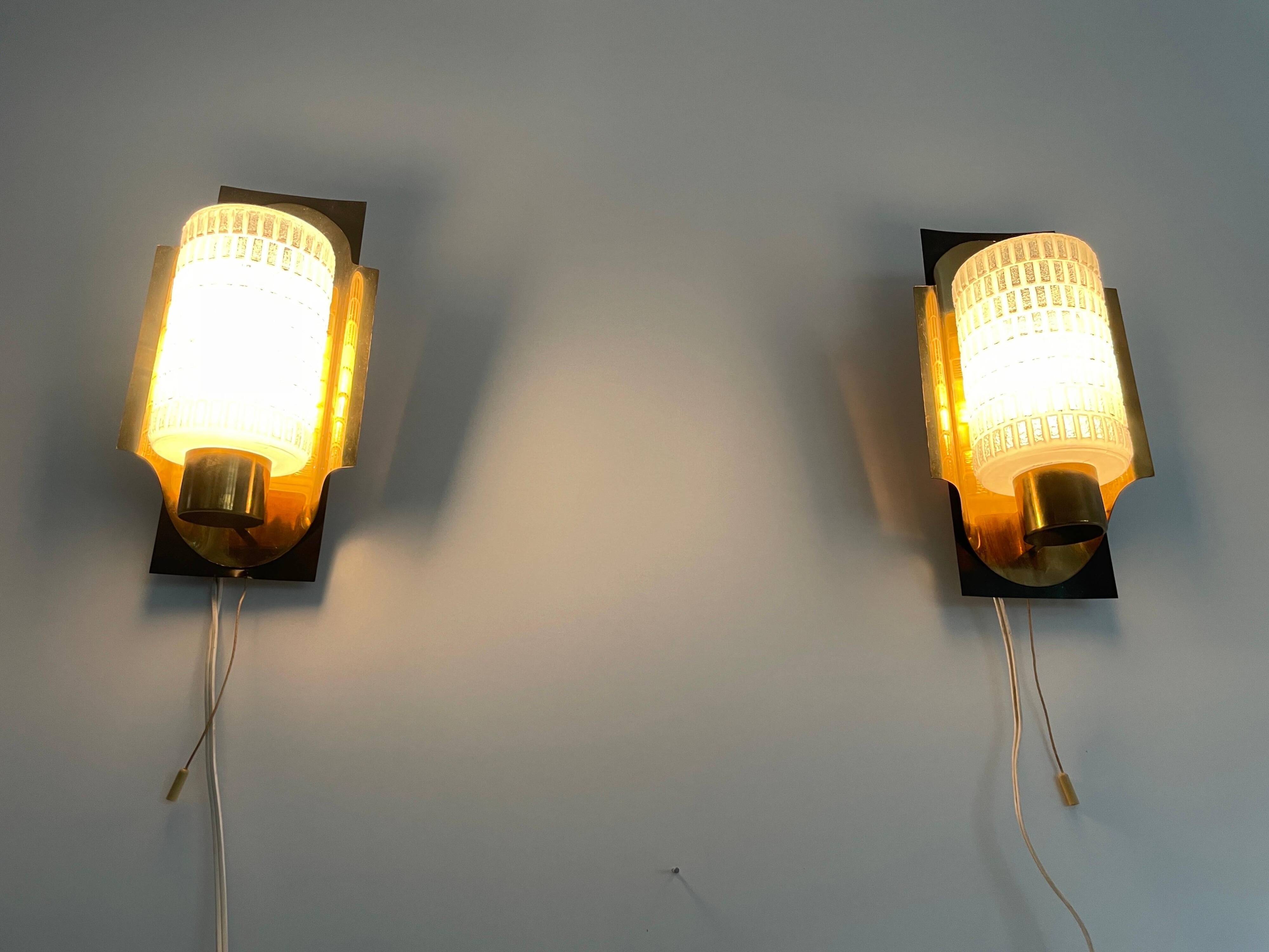 Mid-century pair of wall sconces in textured glass and brass, 1950s, Germany.