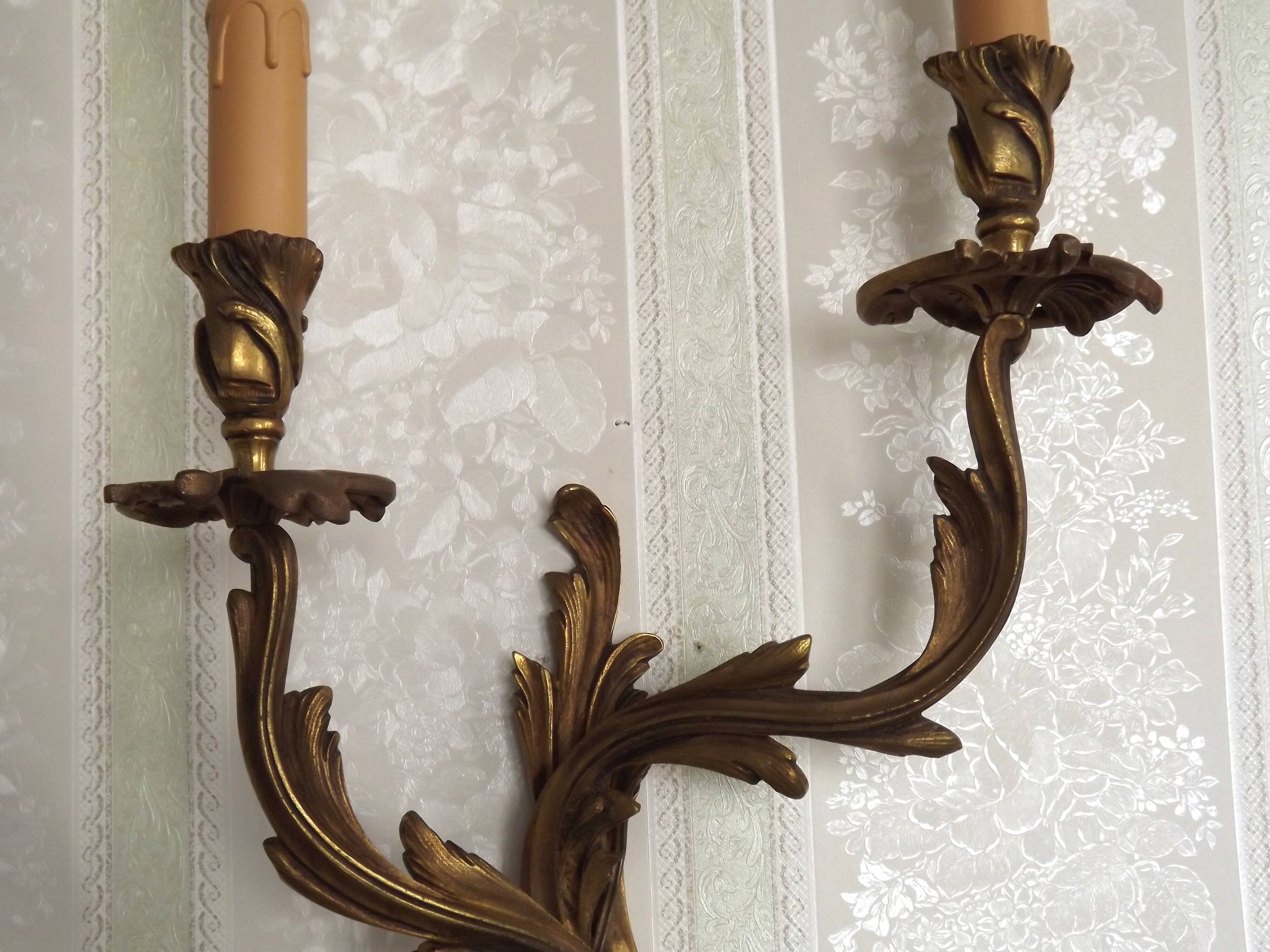 Apply two bronze wall lights decorated with acanthus leaves.