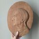 Oval wooden relief portrait of a cardinal.