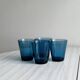 Four small translucent blue glasses.