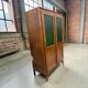 Vintage wooden display cabinet with green glass.