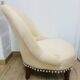 Pale pink upholstered armchair with wooden legs.