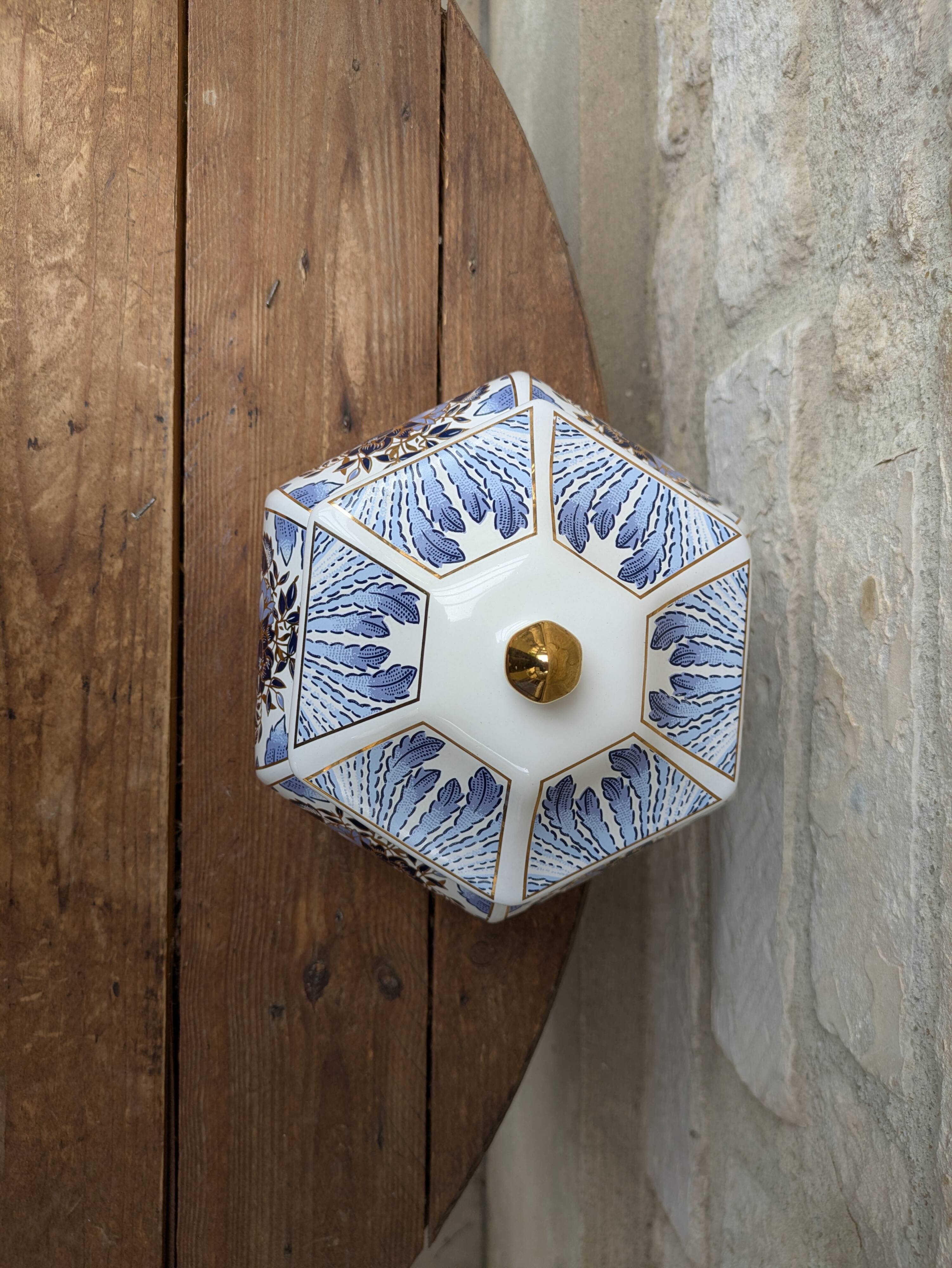 Decorative pot jar with a lid featuring a blue floral pattern and gilding.
