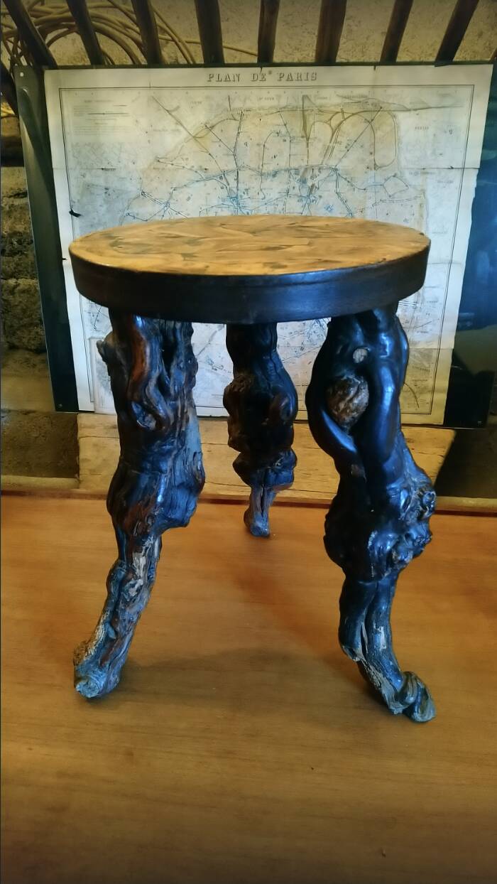 Brutalist tripod stool made from vine stumps.