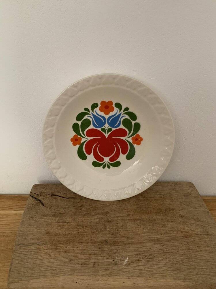 Hungarian folk plate in white ceramic with hand-painted flowers, embossed edge.