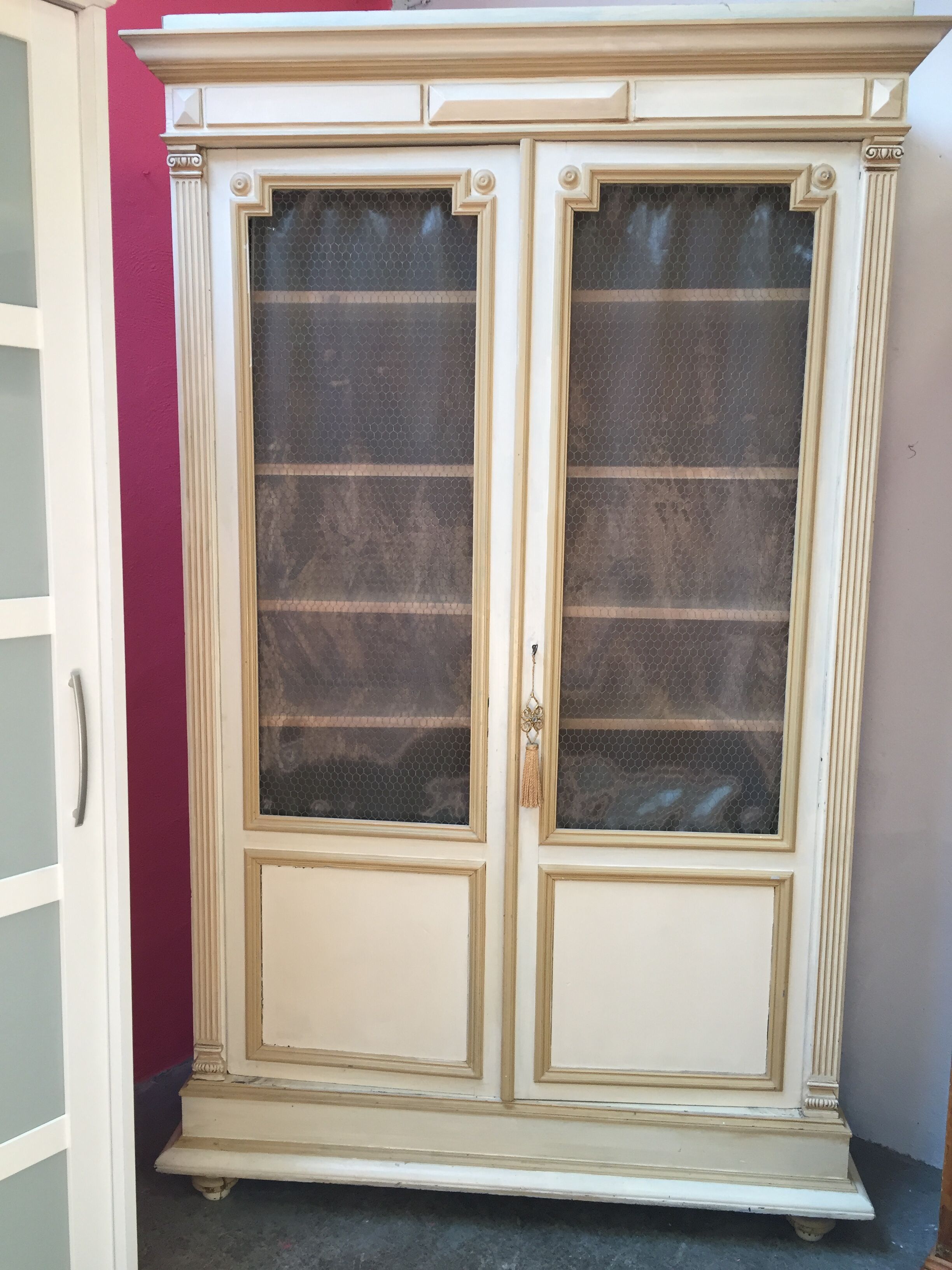 Bookcase 2 painted in ochre and cream mesh doors beginning 20 th