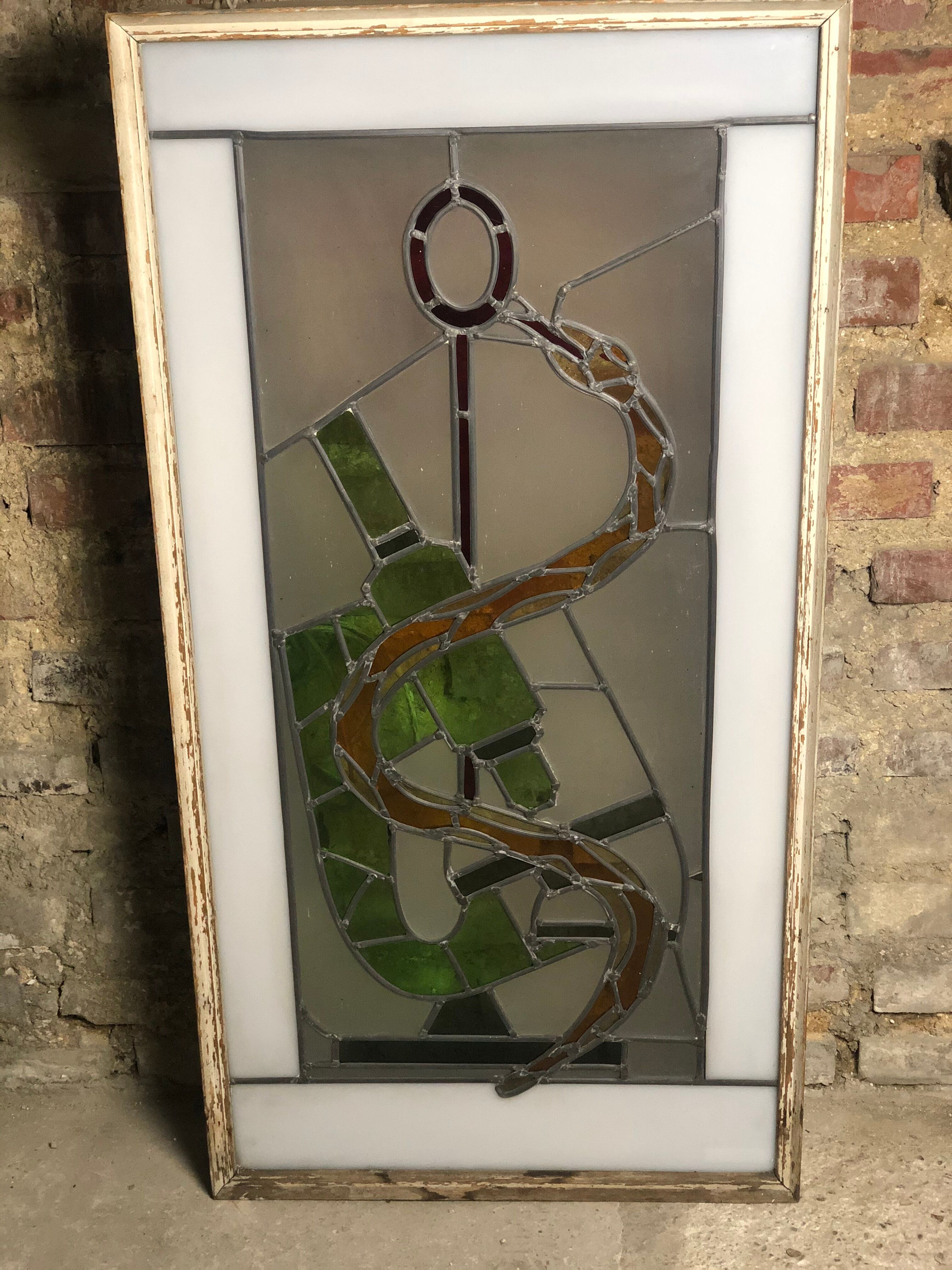 Old stained glass sign with deciduous decoration and microscope