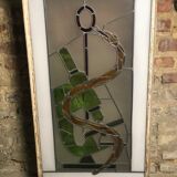 Old stained glass sign with deciduous decoration and microscope