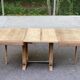 Art Deco dining table with a central pedestal, stripped in solid oak, with 2 extensions.