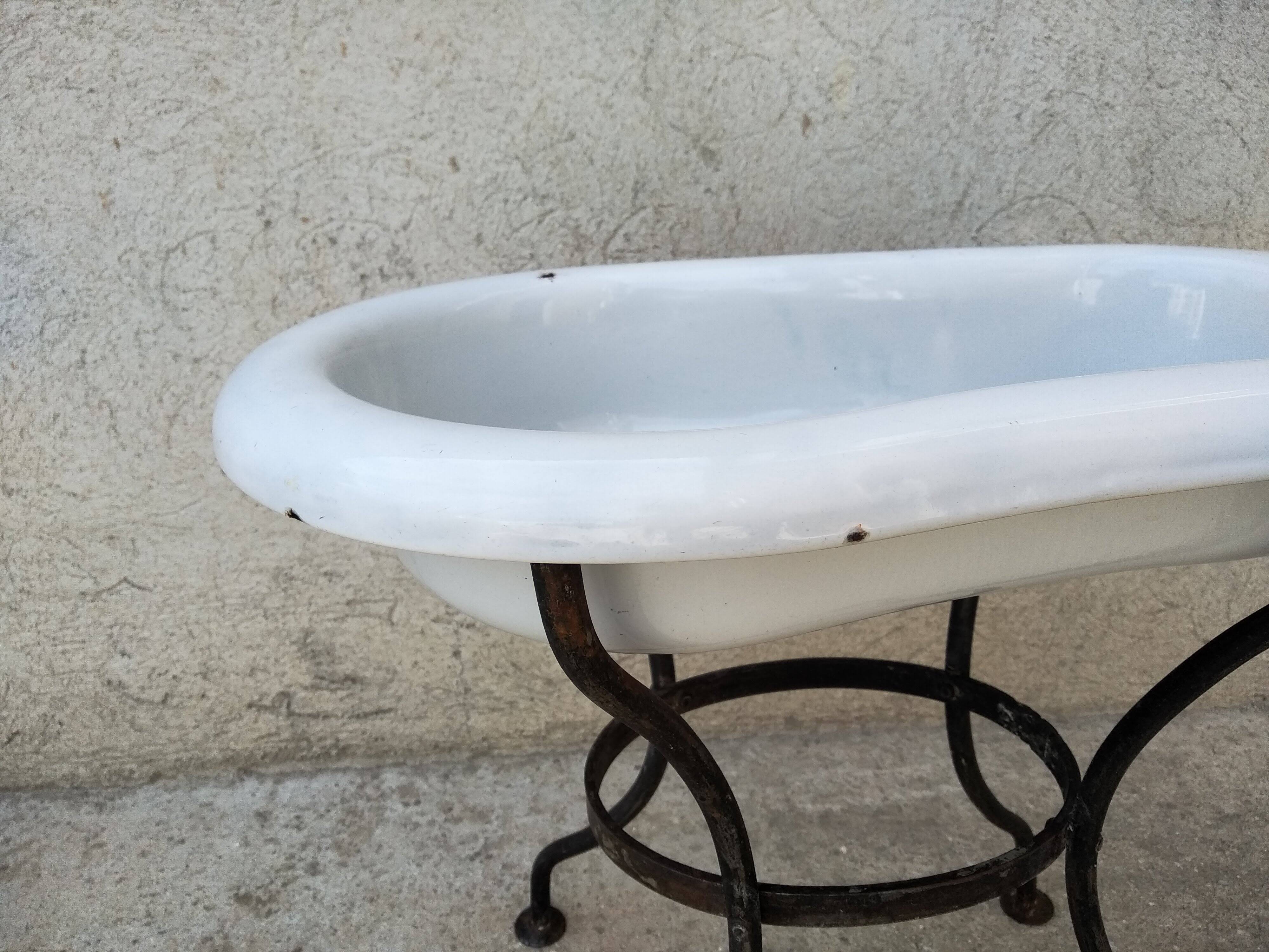Antique bidet in enamelled sheet metal with wrought iron support