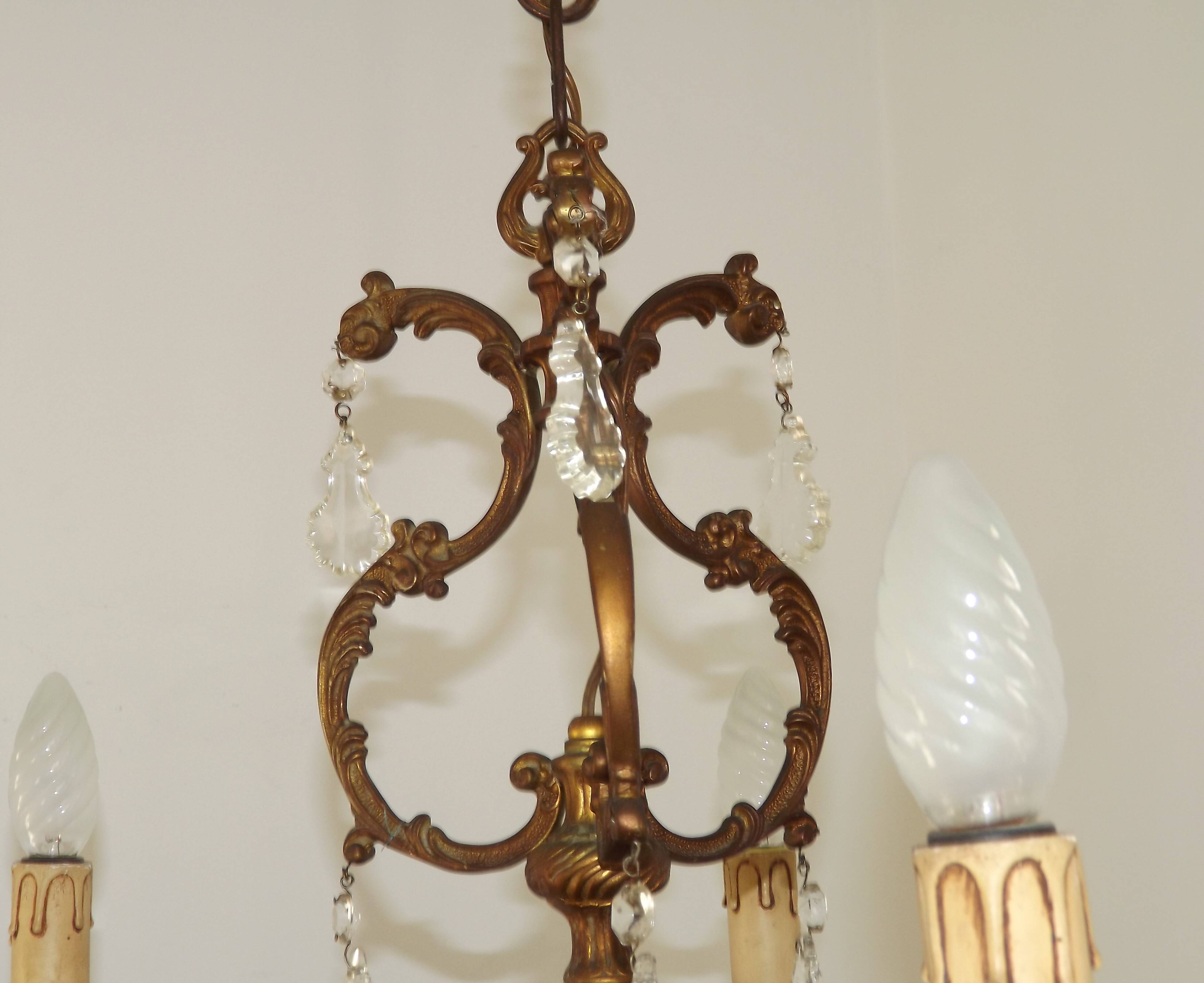 Antique French bronze chandelier with 6 lights and matching crystals.