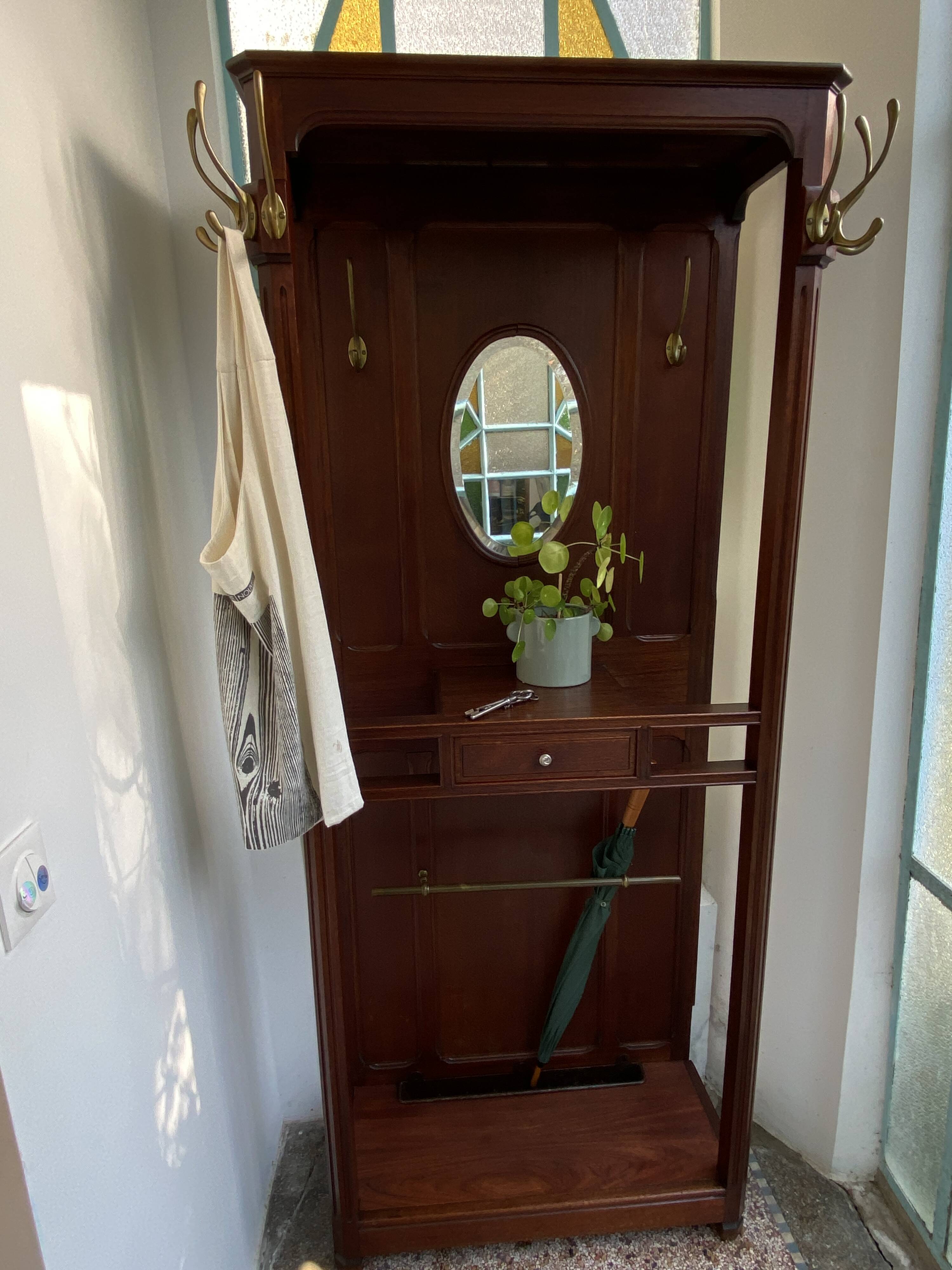 Antique wooden coat rack with mirror and shelf.