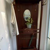 Antique wooden coat rack with mirror and shelf.