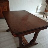 Solid wood dining table with a sculptural base.